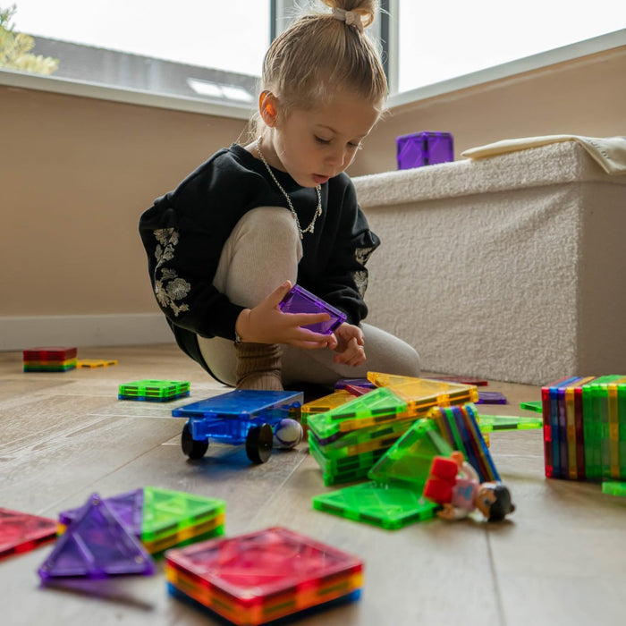 Meisje speelt thuis met magnetische tegels